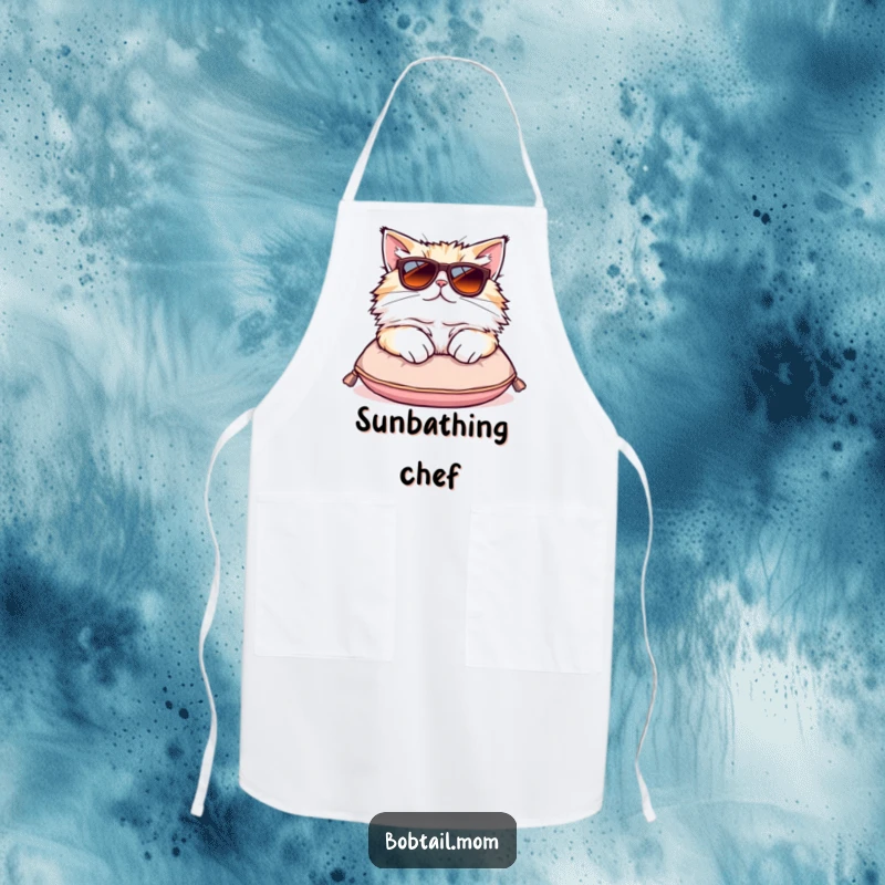 Funny Bobtail cat apron showing a fluffy cat in oversized sunglasses lounging on a cushion, perfect for a stylish cook.