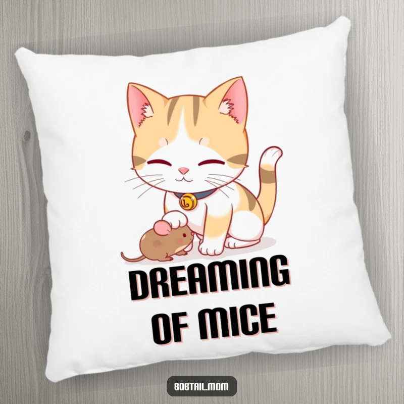 Funny Bobtail cat with a bell collar playfully nudging a toy mouse, featured on a soft, plush pillow.
