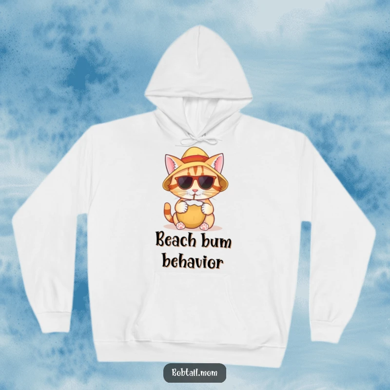 Funny hoodie depicting a bobtail cat wearing a sun hat, enjoying a coconut drink, radiating a relaxed tropical persona.