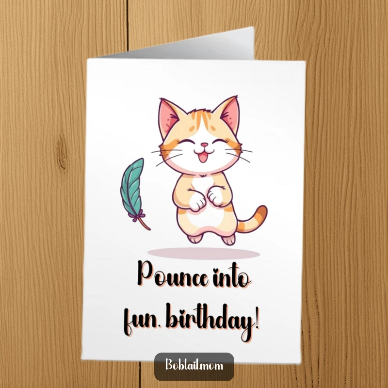 Funny Free Printable Birthday Card: A Bobtail cat in a playful leap, chasing a feather toy.