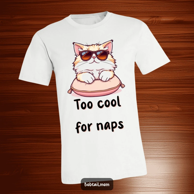 Funny Bobtail cat t-shirt showing a fluffy cat wearing oversized sunglasses while lounging on a small cushion.