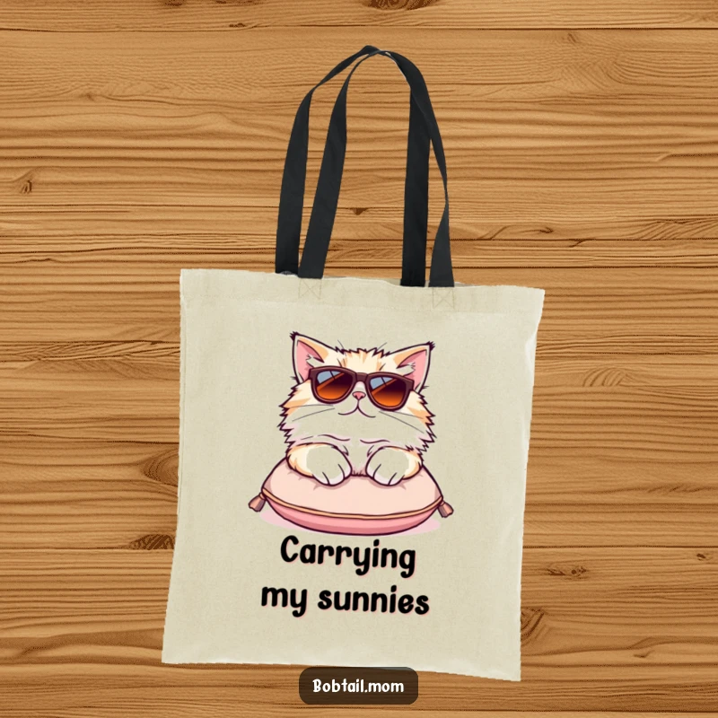Funny Bobtail cat tote bag showcasing a fluffy cat in oversized sunglasses lounging on a cushion, embodying chic style.